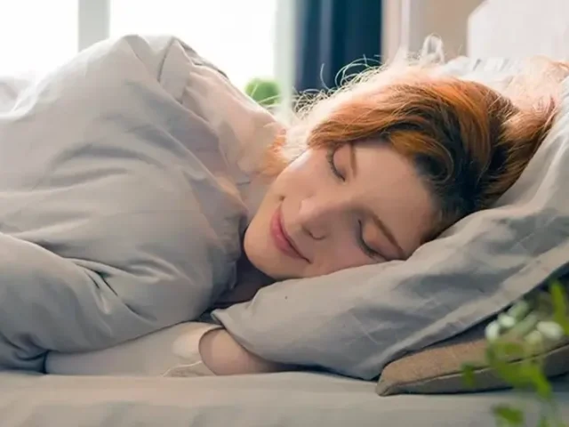Woman sleeping snugly in her bed