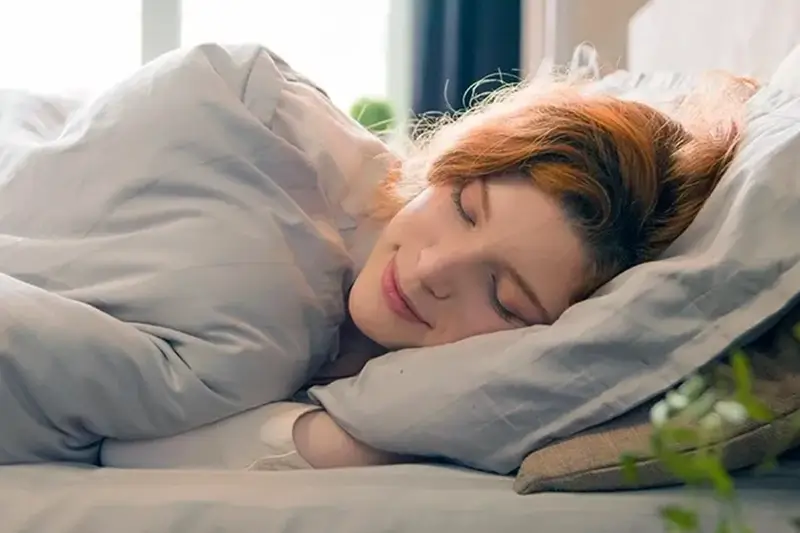 Woman sleeping snugly in her bed